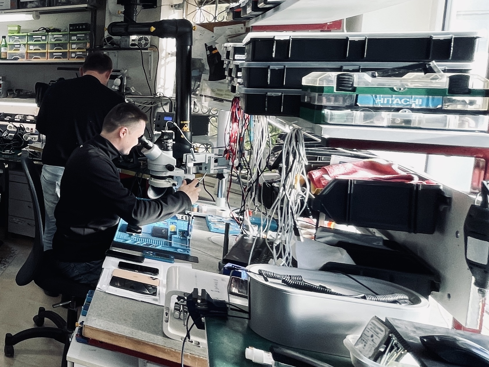 Technik i-SRC podczas naprawy płyty głównej pod mikroskopem